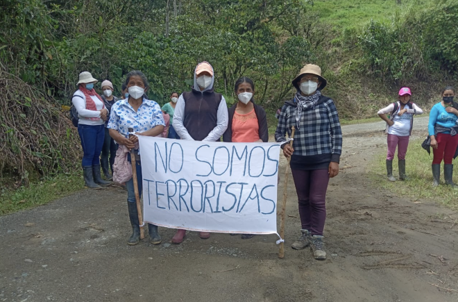 Mujeres acusadas de terrorismo por defender la vida y la naturaleza frente a la minería protestan con un cartel "No somos terroristas"