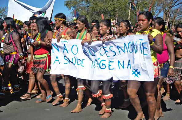 Mujeres indígenas de brasil protestan contra la destrucción de sus territorios con una pancarta en la que dice “Nao ao desmonte” contra la deforestación de la selva tropical