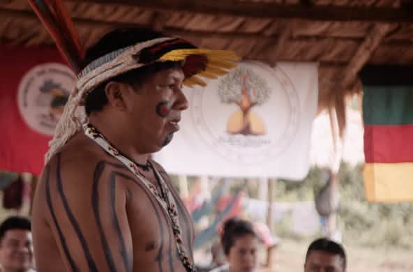 Líder indígena Ithau Ka'apor, de perfil, hablando en una reunión