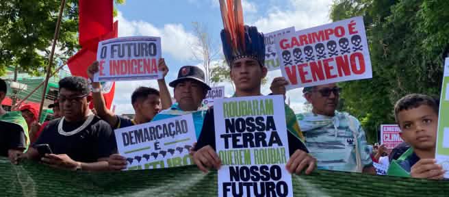 Indígenas marchando sostienen pancartas en las que se lee en portugués: Robaron nuestra tierra, quieren robar nuestro futuro” y “El futuro es indígena”
