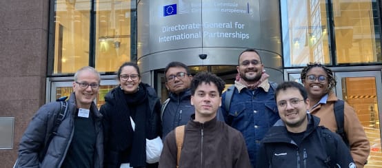 Foto de grupo de 7 personas frente a la entrada de un edificio de la Comisión de la UE en Bruselas