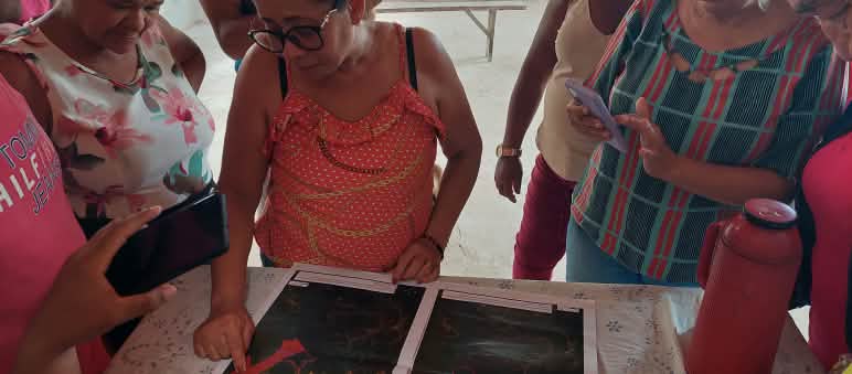 Discutiendo sobre el mapa con los límites de la tierra ancestral en la comunidad de Timbiras Una representante de la Comisión Pastoral de la Tierra (CPT), presenta un mapa con los límites de la tierra ancestral de la comunidad de Timbiras