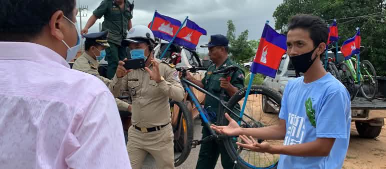 Una y otra vez, las autoridades obstaculizan las protestas y amenazan a quienes ejercen y defienden sus derechos. Aquí, la policía confisca bicicletas tras una manifestación pacífica por la protección de la isla de Koh Kong. Ambientalista discute con policía tras confisación de bicicletas. Un policía fotografía la escena.