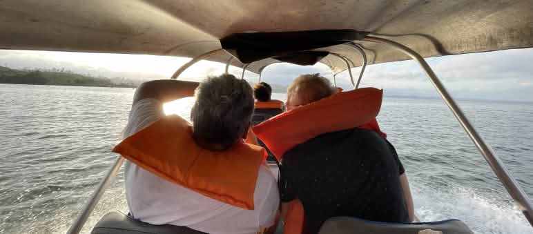 Miembros de Xingu Vivo y Salva la Selva navegan hacia la Volta Grande do Xingu para una inspección del territorio Personas con salvavidas en una embarcación navegando con el sol del amanecer de frente