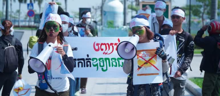 Mother Nature Cambodia llega a muchas personas con sus acciones de protesta creativas y valientes Un grupo de jóvenes estudiantes caminan por una calle portando megáfonos y pancartas