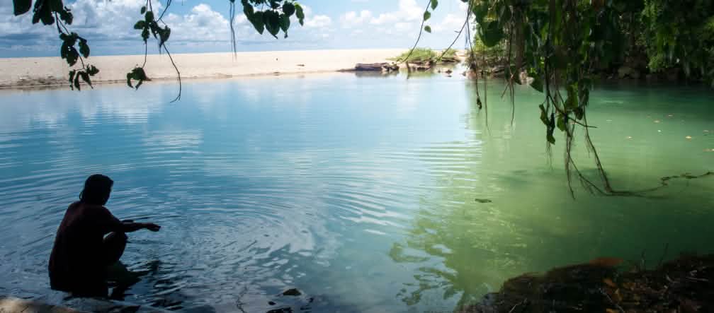 La isla de Célebes tiene 6.000 kilómetros de costas con playas de arena Una mujer en el agua en una bahía rodeada de rocas y arena