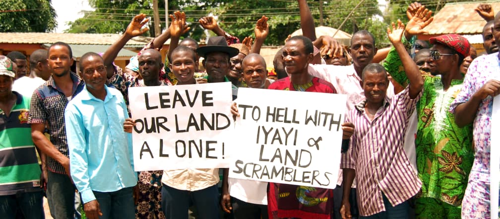 Protesta contra la empresa de plantaciones Okomu Oil Palm Oil en Nigeria En protesta contra Okomu Oil Palm Oil en Nigeria, algunos afectados sostienen pancartas con leyendas como "Dejen nuestras tierras en paz" y otras