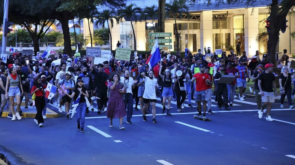 Un gran grupo de personas protestan en las calles con pancartas y banderas de Panamá en contra de la minería en 2023