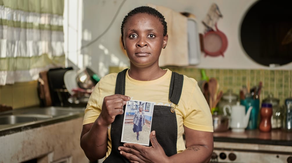 Malungelo Xhakaza  se encuentra en su cocina y muestra la foto de su madre