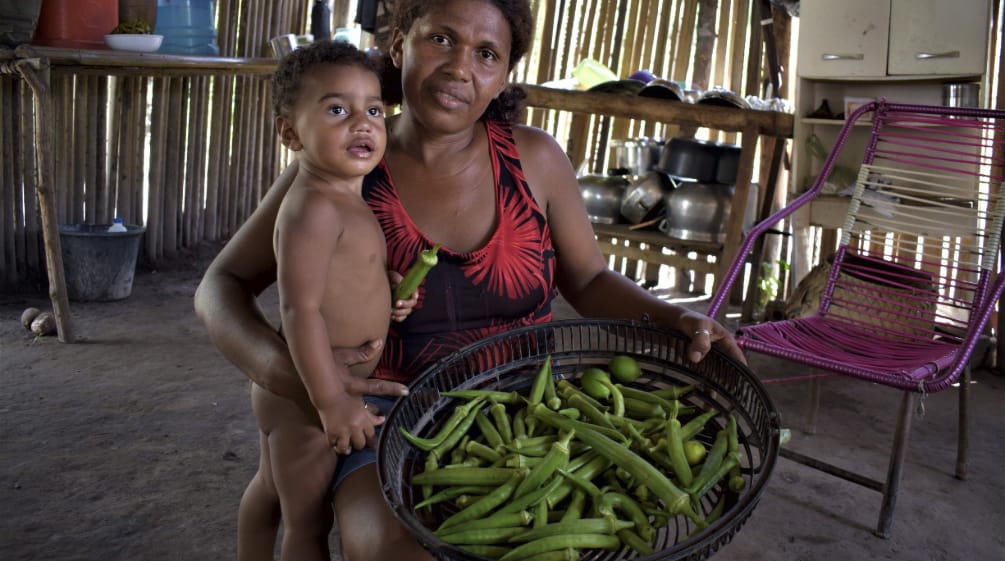 Familia muestra a la cámara su cosecha de okra